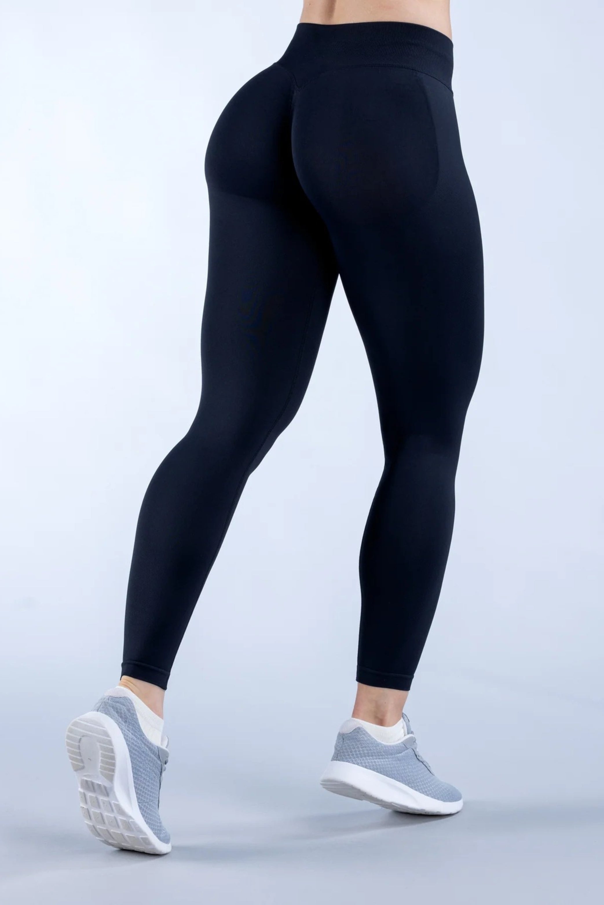 Zwarte Kiara legging - zijkant in beweging, met stretchy stof en ondersteunende shaping fit