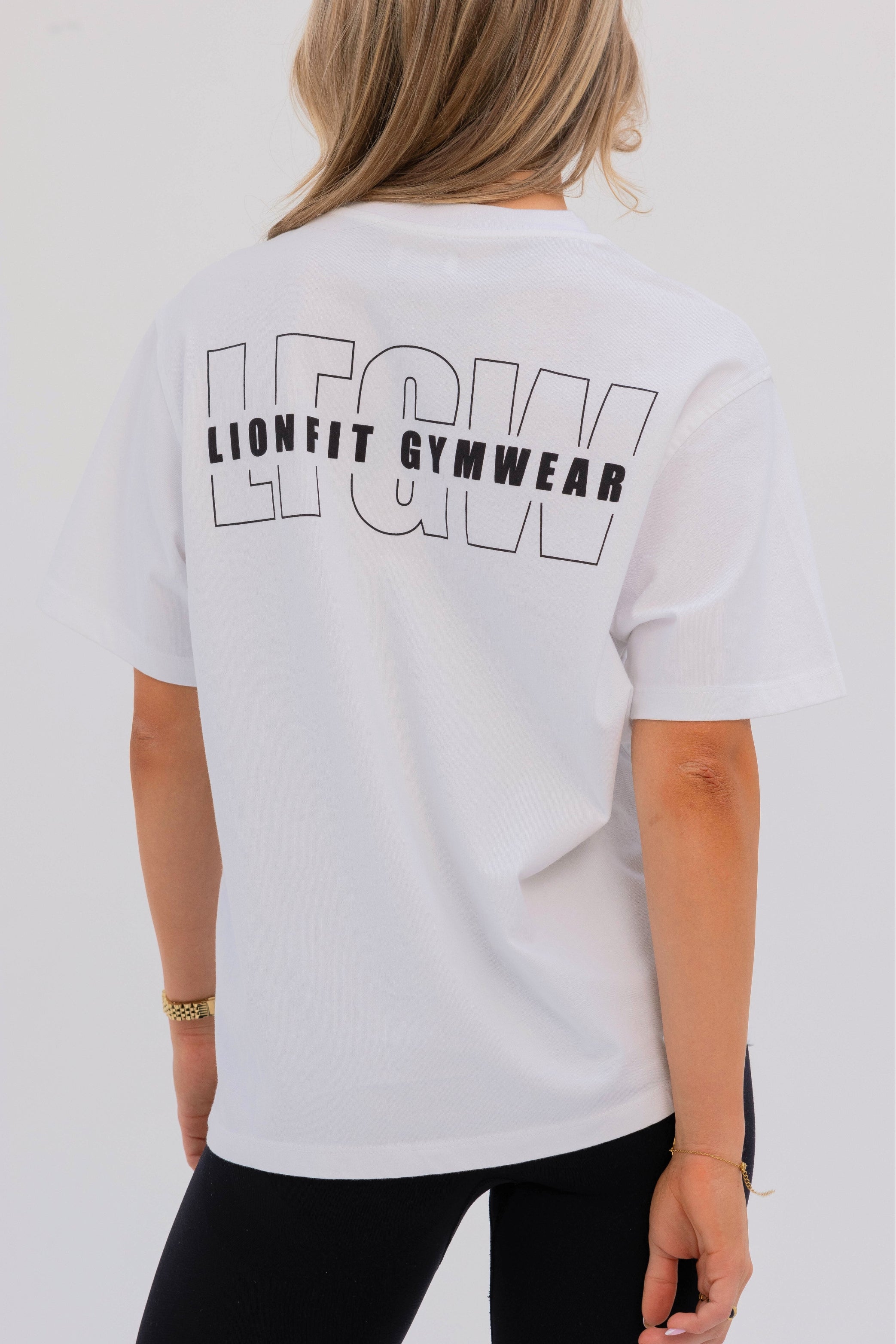 Achteraanzicht van de witte Nala tee - met Lionfit branding en comfortabele oversized fit
