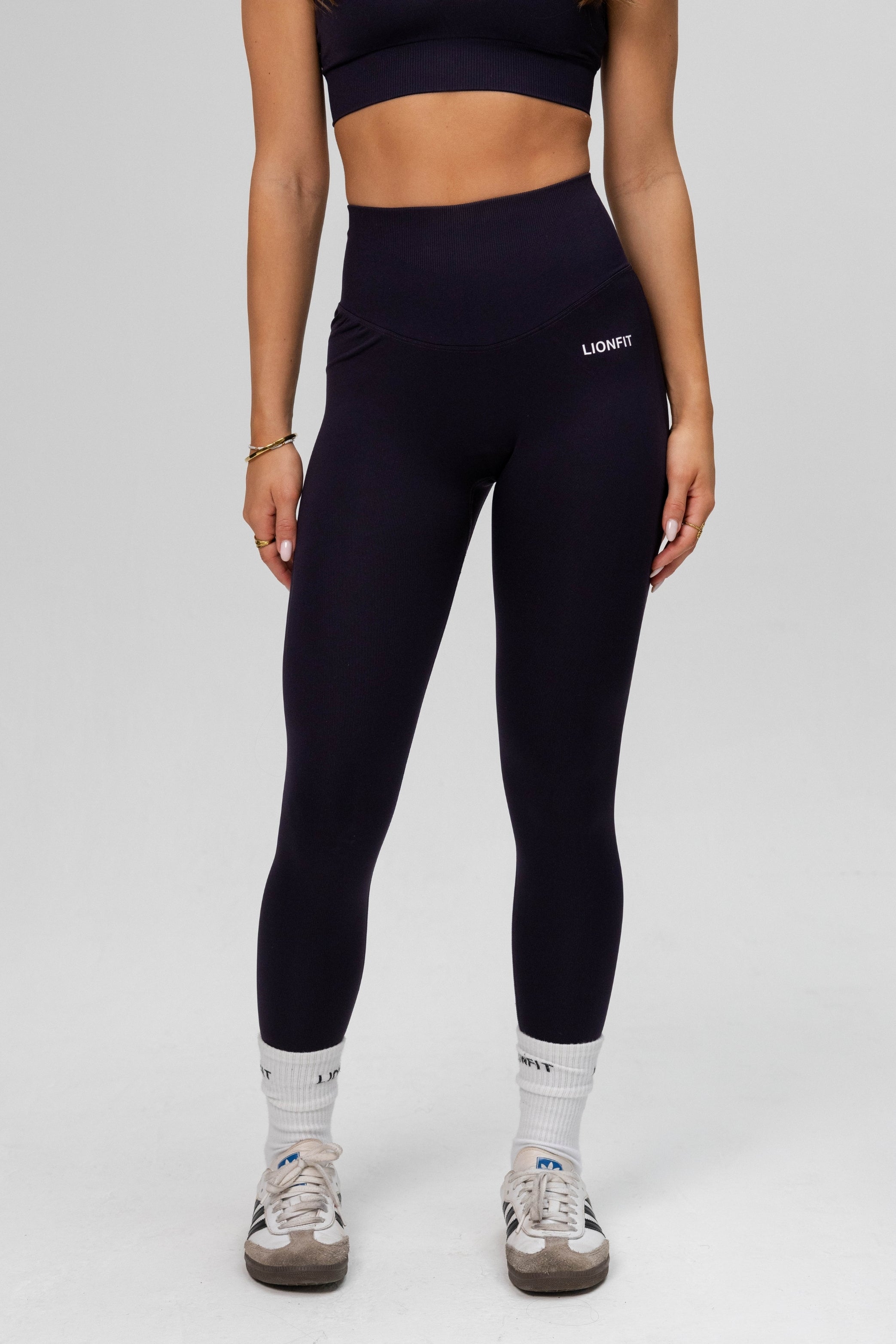 Full body vooraanzicht van vrouw in Lion Fit Safa Seamless Legging navy blue en bijpassende sport-bh.