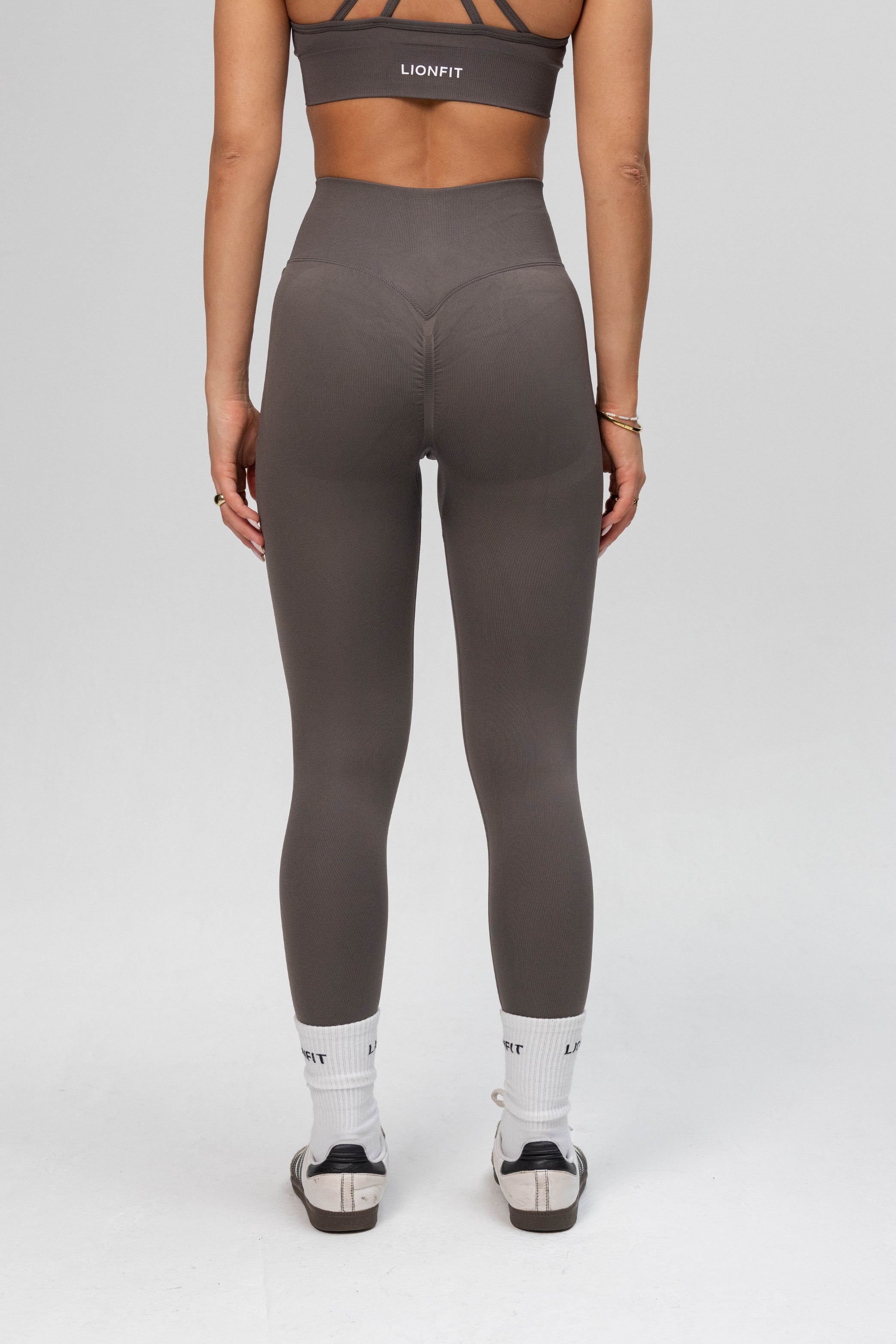Achteraanzicht van de Safa Seamless Legging in Stone Grey van Lionfit Gymwear, met een flatterend design en uitstekende ondersteuning tijdens het sporten.
