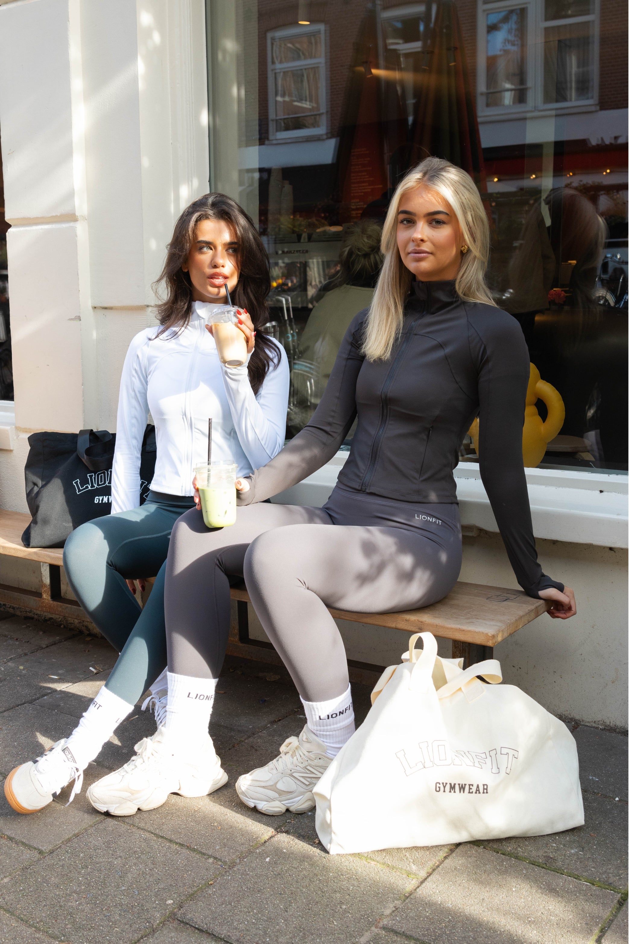 Vrouw met de Essential Totebag Beige van Lionfit Gymwear in sportieve outfit, buiten bij daglicht. Grote katoenen shopper tas perfect voor sportschool, strand of dagelijks gebruik, gemaakt van duurzaam gerecycled materiaal.