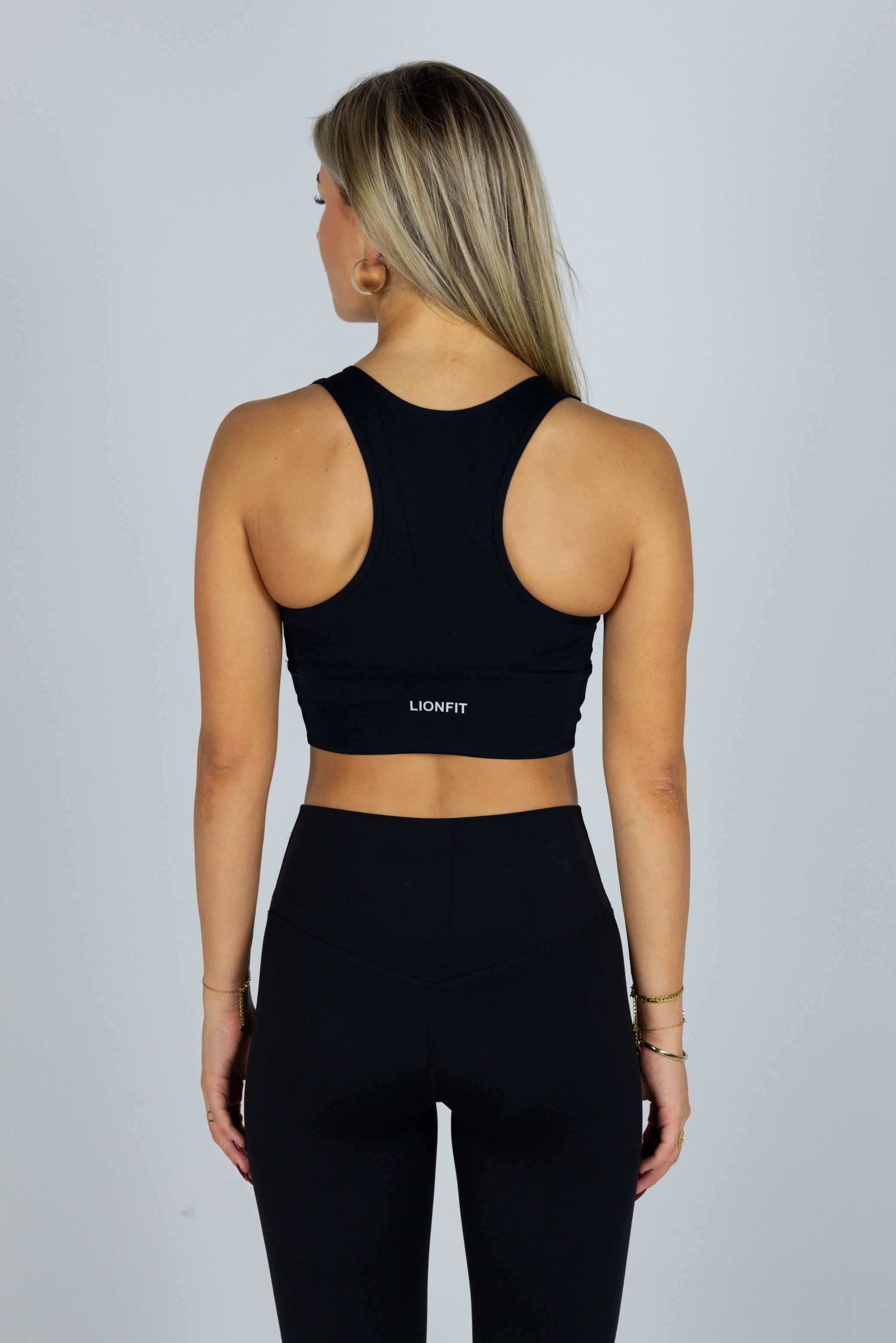 Lionfit Essential Bra Black Long - Naadloze lange sport-bh voor dames, biedt extra ondersteuning en comfort, ideaal voor intensieve trainingen en dagelijkse activiteiten, gedragen door model