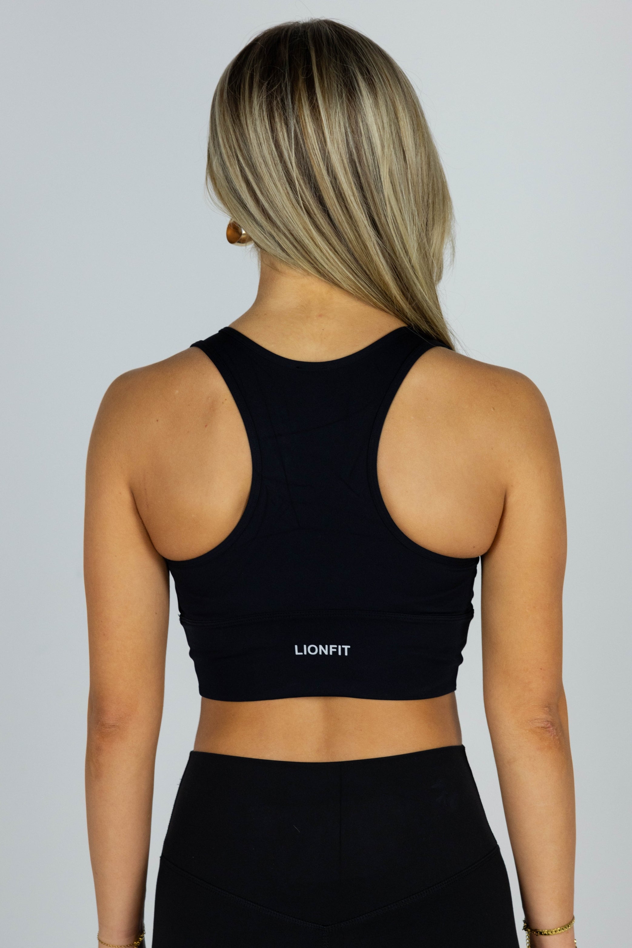 Lionfit Essential Bra Black Long - Naadloze lange sport-bh voor dames, biedt extra ondersteuning en comfort, ideaal voor intensieve trainingen en dagelijkse activiteiten, gedragen door model