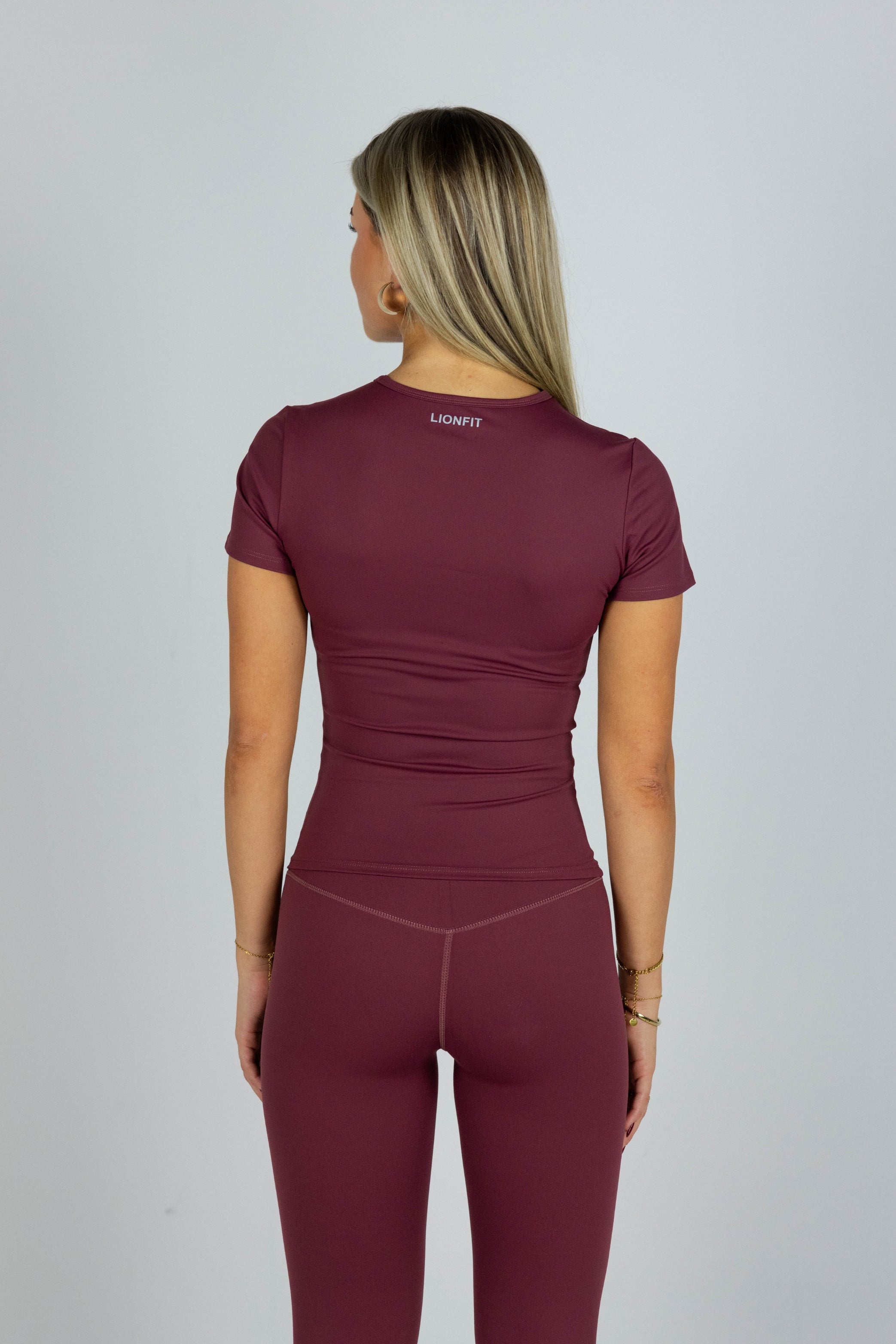 Lionfit Essential Seamless Shortsleeve Top Burgundy gedragen door model, naadloze bordeauxrode dames sporttop, ideaal voor workouts en casual outfits