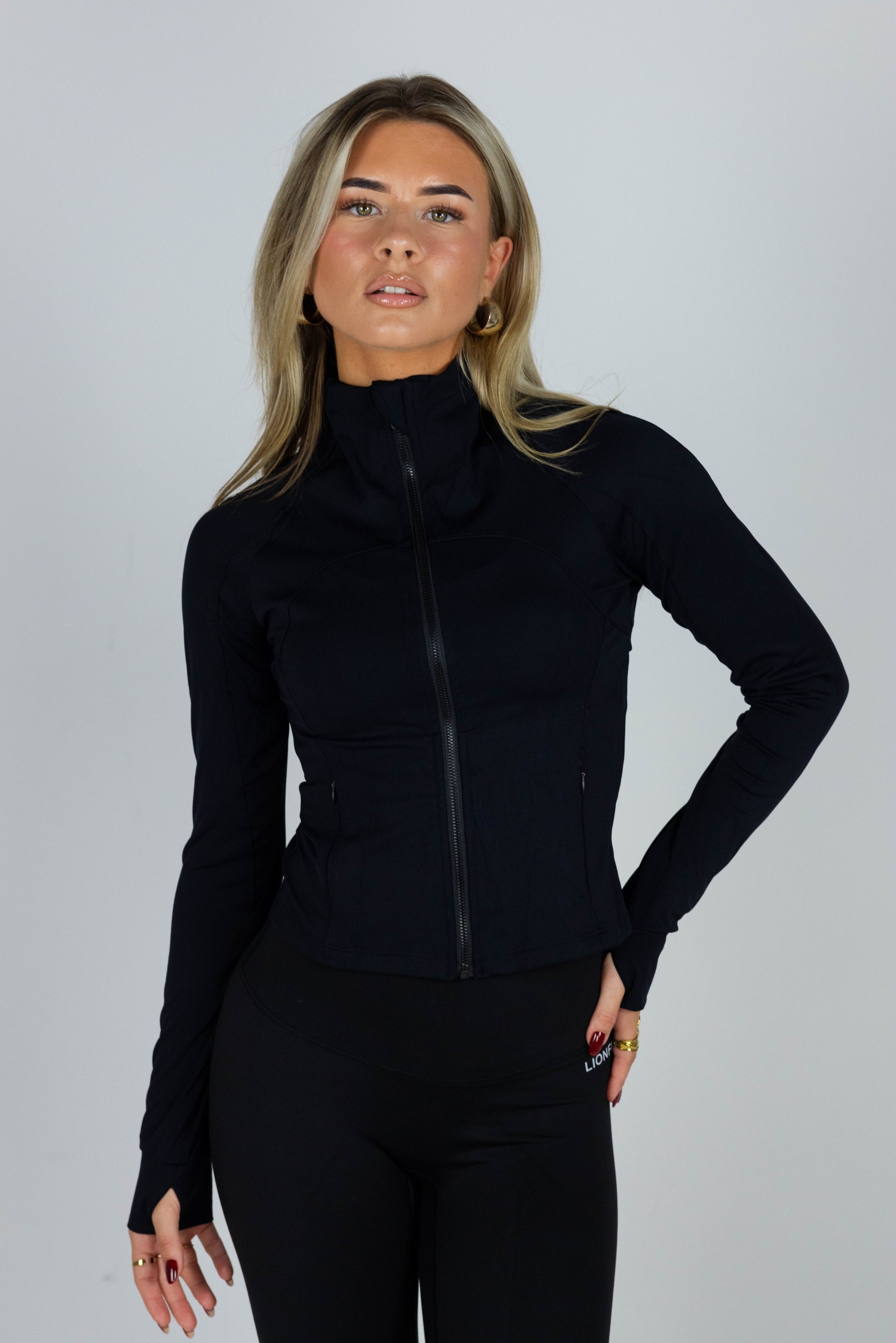 Essential Zip Vest Black voor dames - comfortabele en stijlvolle sportvest met ritssluiting, ideaal voor workouts en casual wear. Model draagt maat S - Lionfit