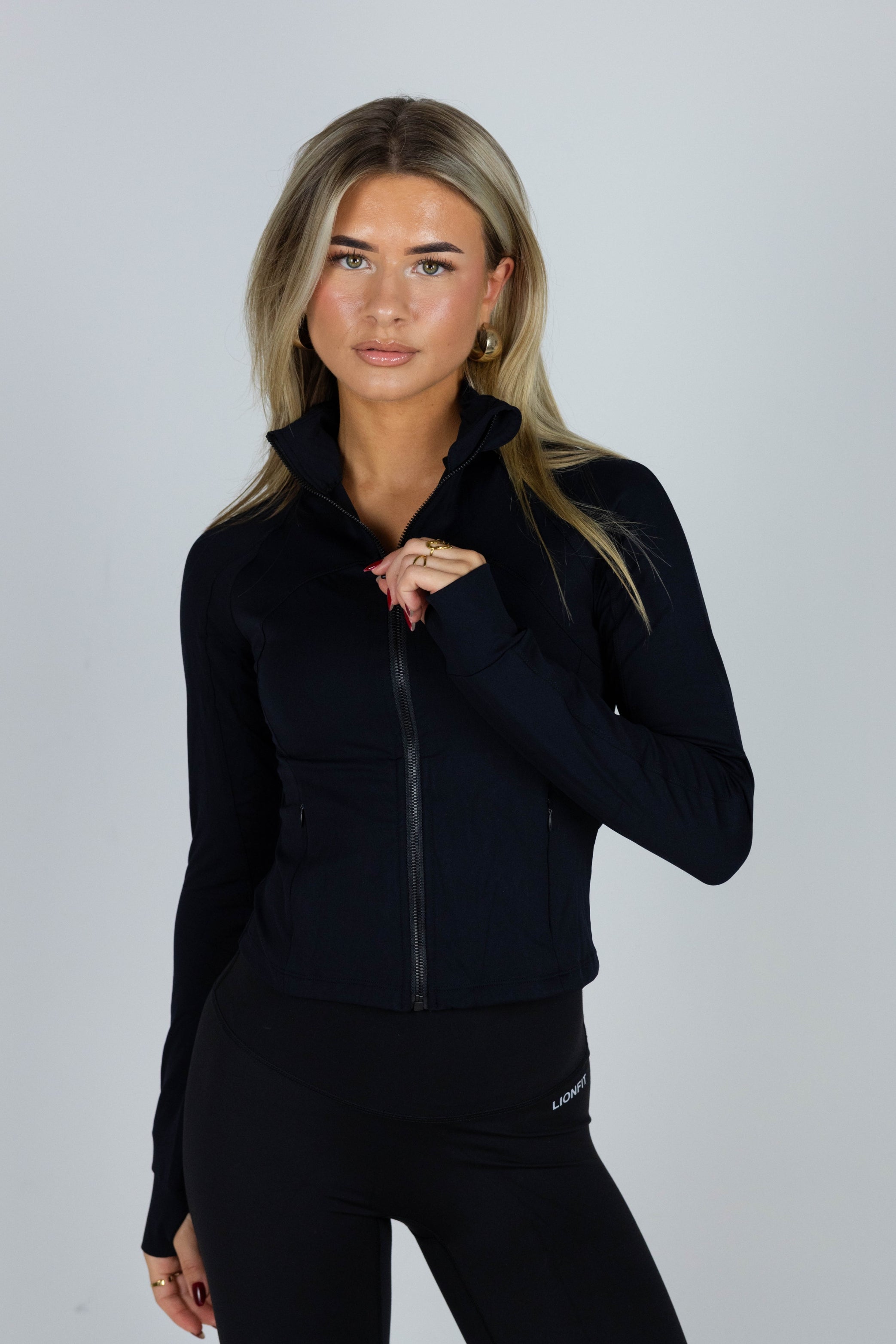 Essential Zip Vest Black voor dames - comfortabele en stijlvolle sportvest met ritssluiting, ideaal voor workouts en casual wear. Model draagt maat S - Lionfit