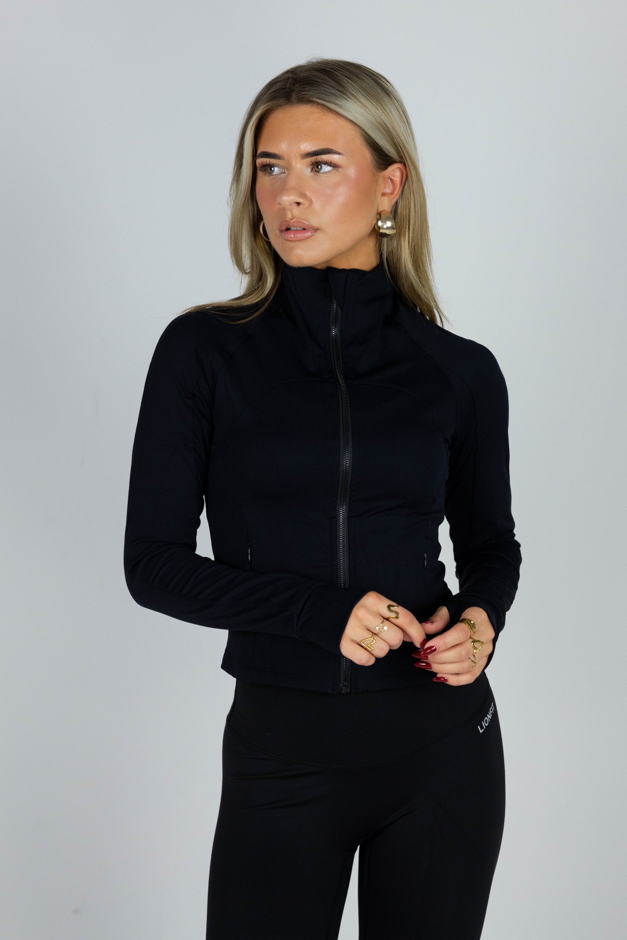 Essential Zip Vest Black voor dames - comfortabele en stijlvolle sportvest met ritssluiting, ideaal voor workouts en casual wear. Model draagt maat S - Lionfit