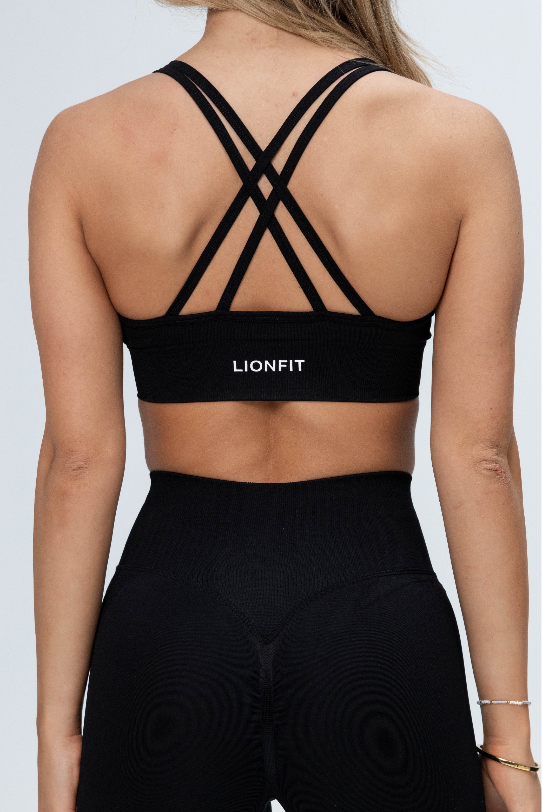 Achteraanzicht van de Safa Seamless Bra Black van Lionfit Gymwear met verstelbare bandjes en een naadloos design.