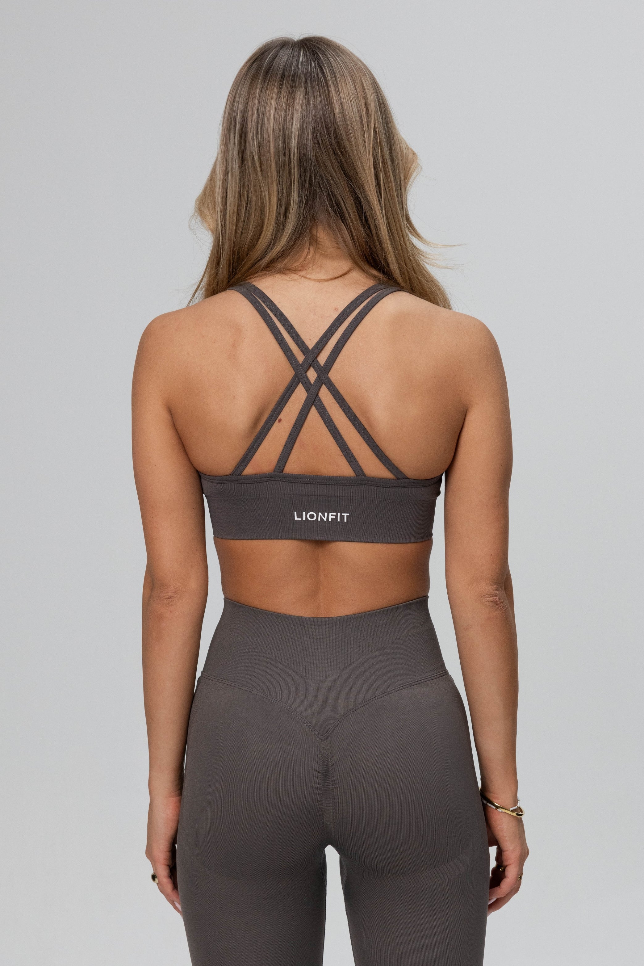 Achteraanzicht van de Safa Seamless Bra in Stone Grey van Lionfit Gymwear, met een naadloos design voor optimaal draagcomfort tijdens het sporten.