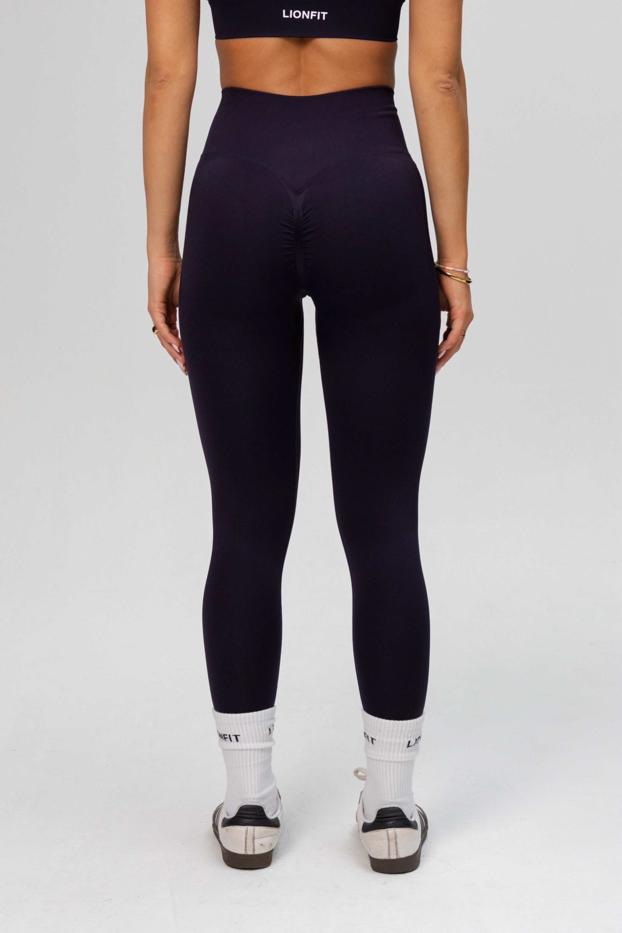 Achteraanzicht van vrouw met Lion Fit Safa Seamless Legging navy blue, scrunch detail aan de achterkant voor een flatterende look.