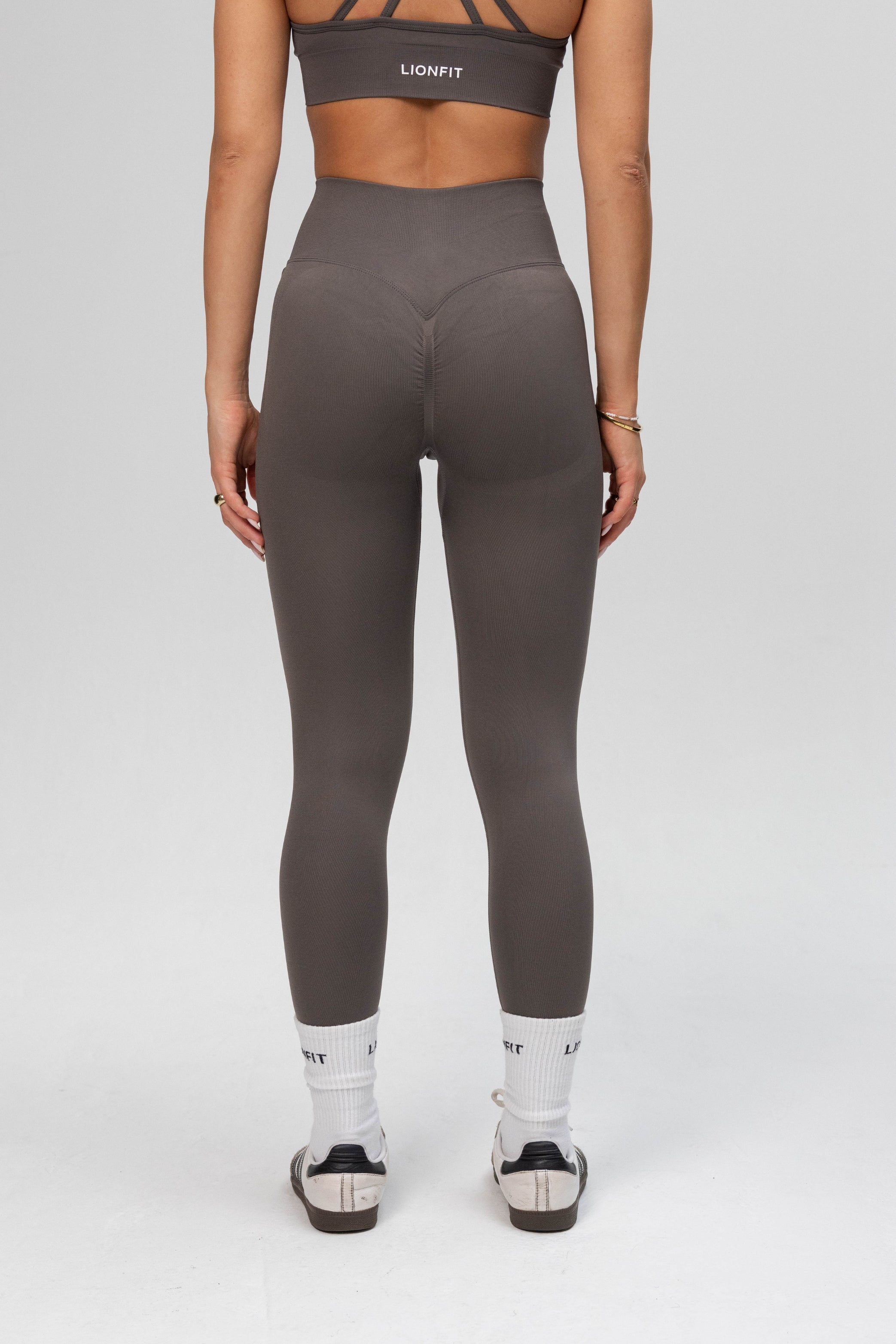 Achteraanzicht van de Safa Seamless Legging in Stone Grey van Lionfit Gymwear, met een flatterend design en uitstekende ondersteuning tijdens het sporten.

