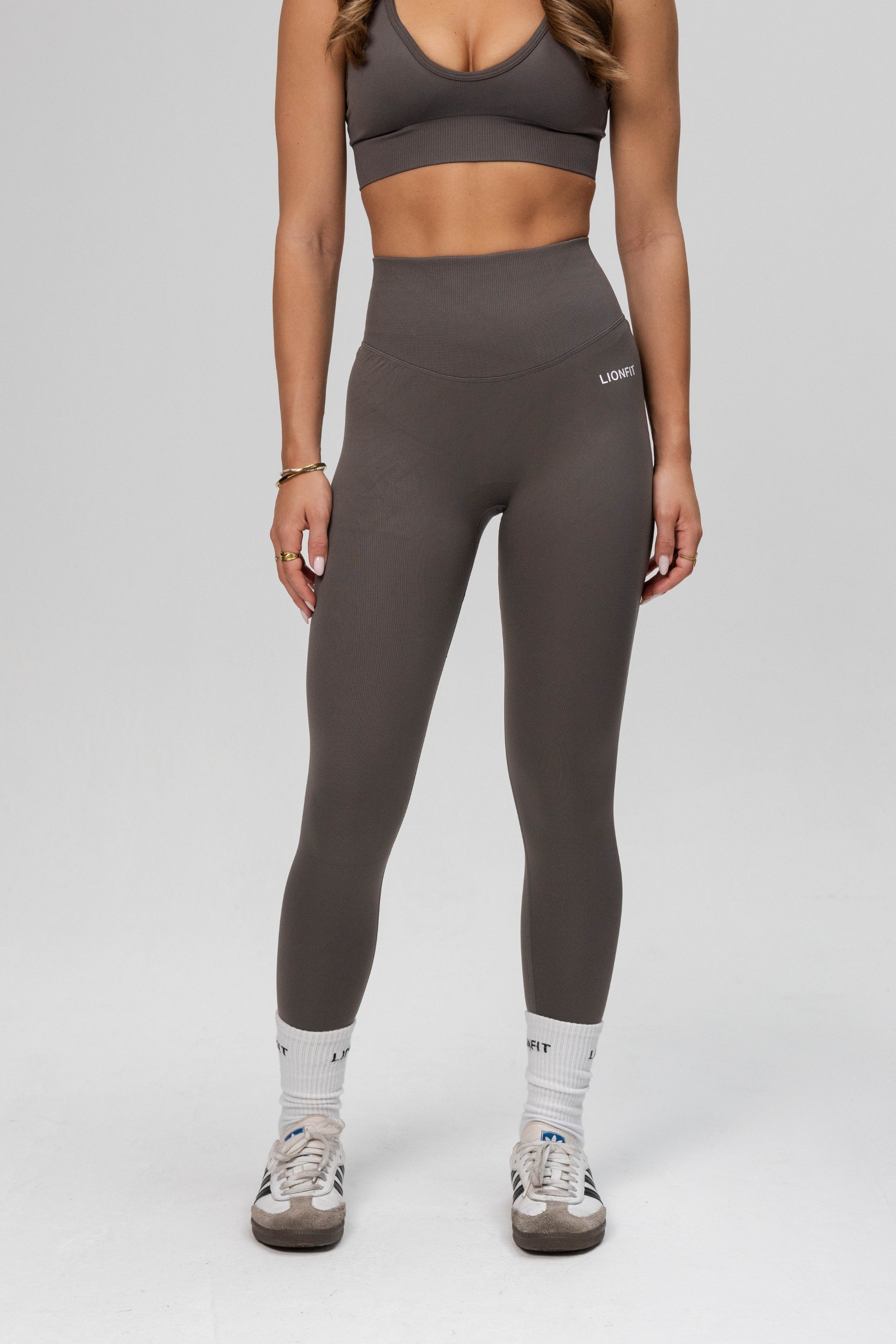 Zijaanzicht van de Safa Seamless Legging in Stone Grey, een naadloze en ademende sportlegging van Lionfit Gymwear, perfect voor actieve vrouwen.